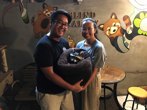 Adi-and-Shelly-holding-a-racoon-at-Blind-Alley